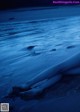 A woman laying on the beach at night. 